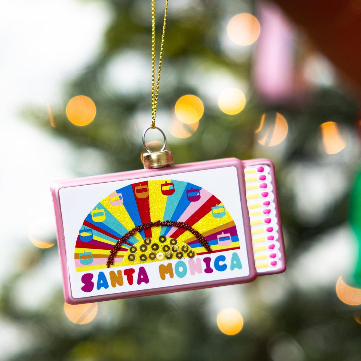 Pink matchbook ornament with Santa Monica logo and gold hanging loop