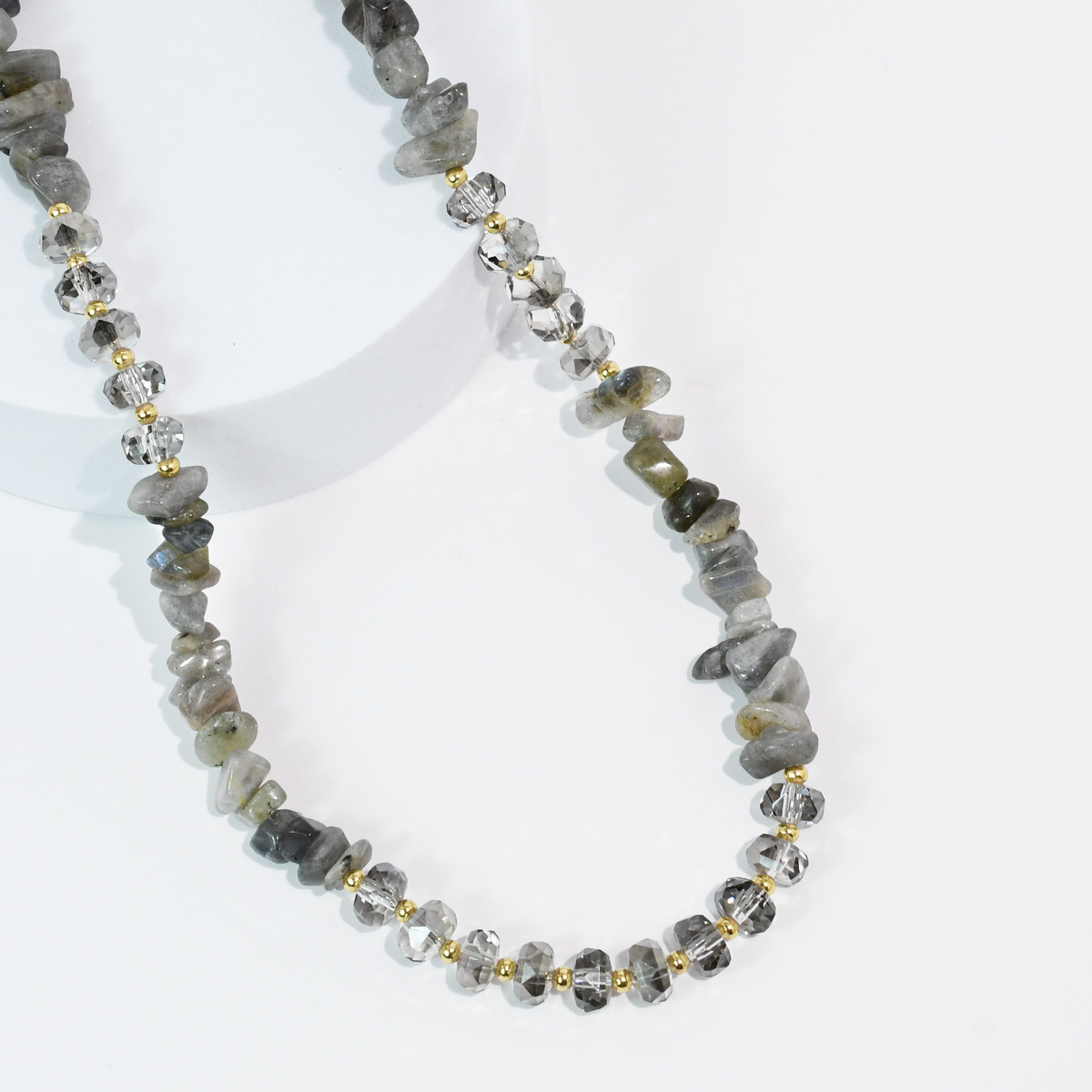 Charcoal gray beaded quartz necklace with faceted stones and gold-tone spacer beads.