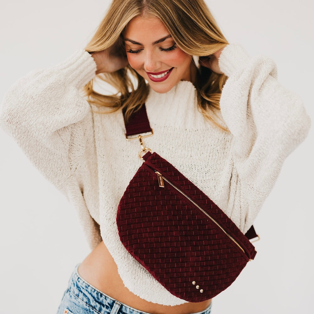 Suede Westlyn woven bum bag in burgundy, zip top and adjustable crossbody strap.