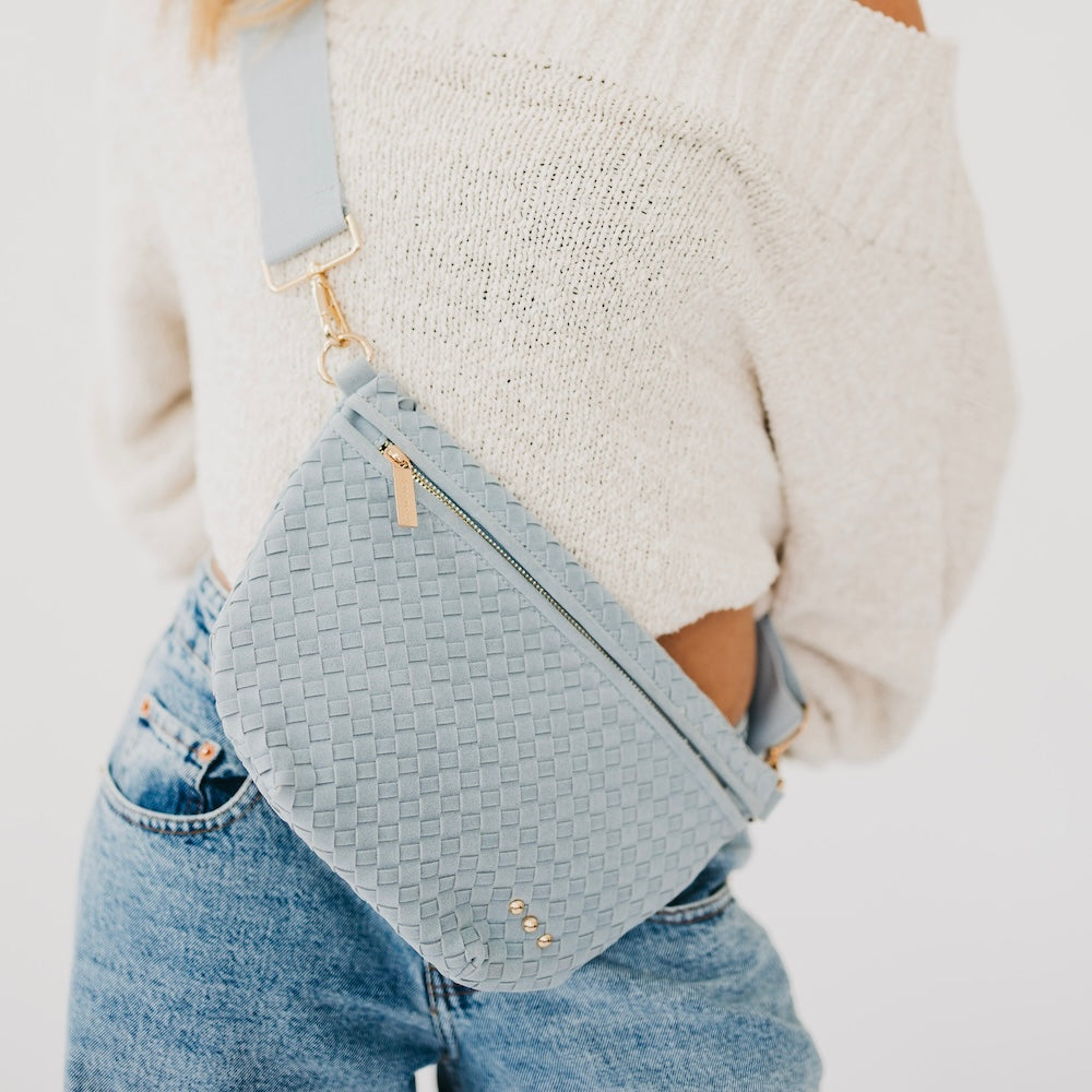 Suede Westlyn woven bum bag in light blue, zip top and adjustable crossbody strap.