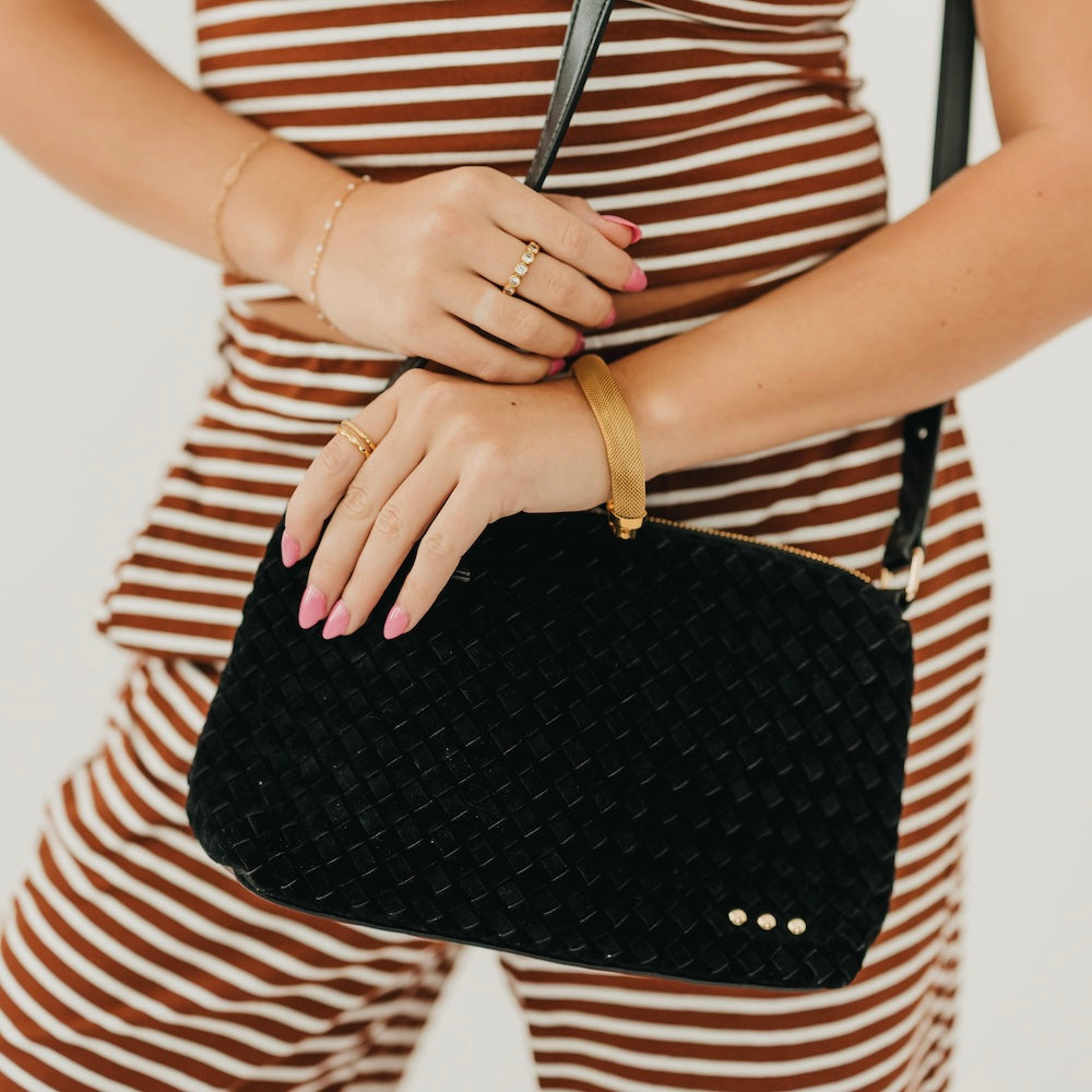 Black woven suede hobo shoulder bag with braided strap and gold snap accents