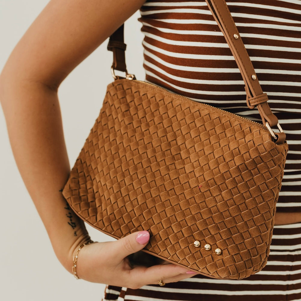 Tan woven suede hobo shoulder bag close-up with braided strap and gold studs