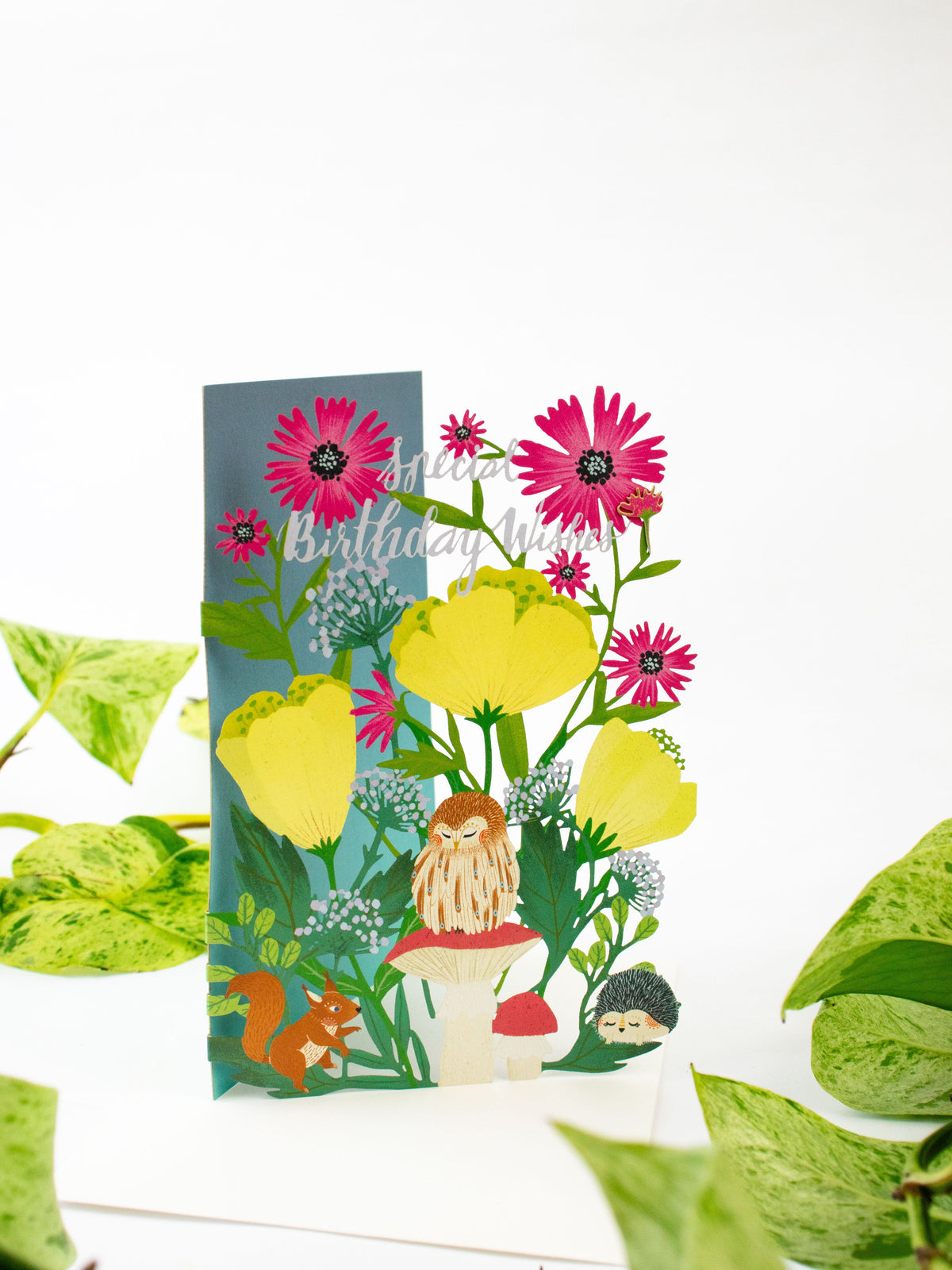 Lasercut birthday card featuring pink gerbera-like blooms, woodland animals, and lion