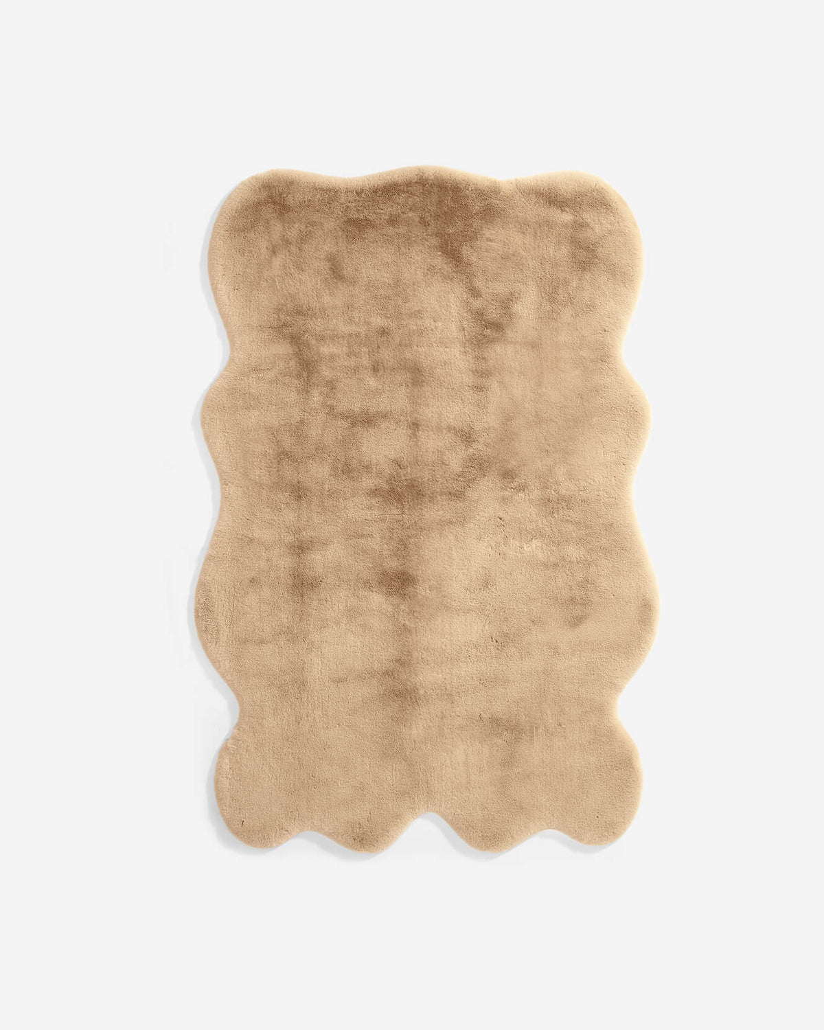 Tan faux fur large rug with wavy edges and soft shag pile