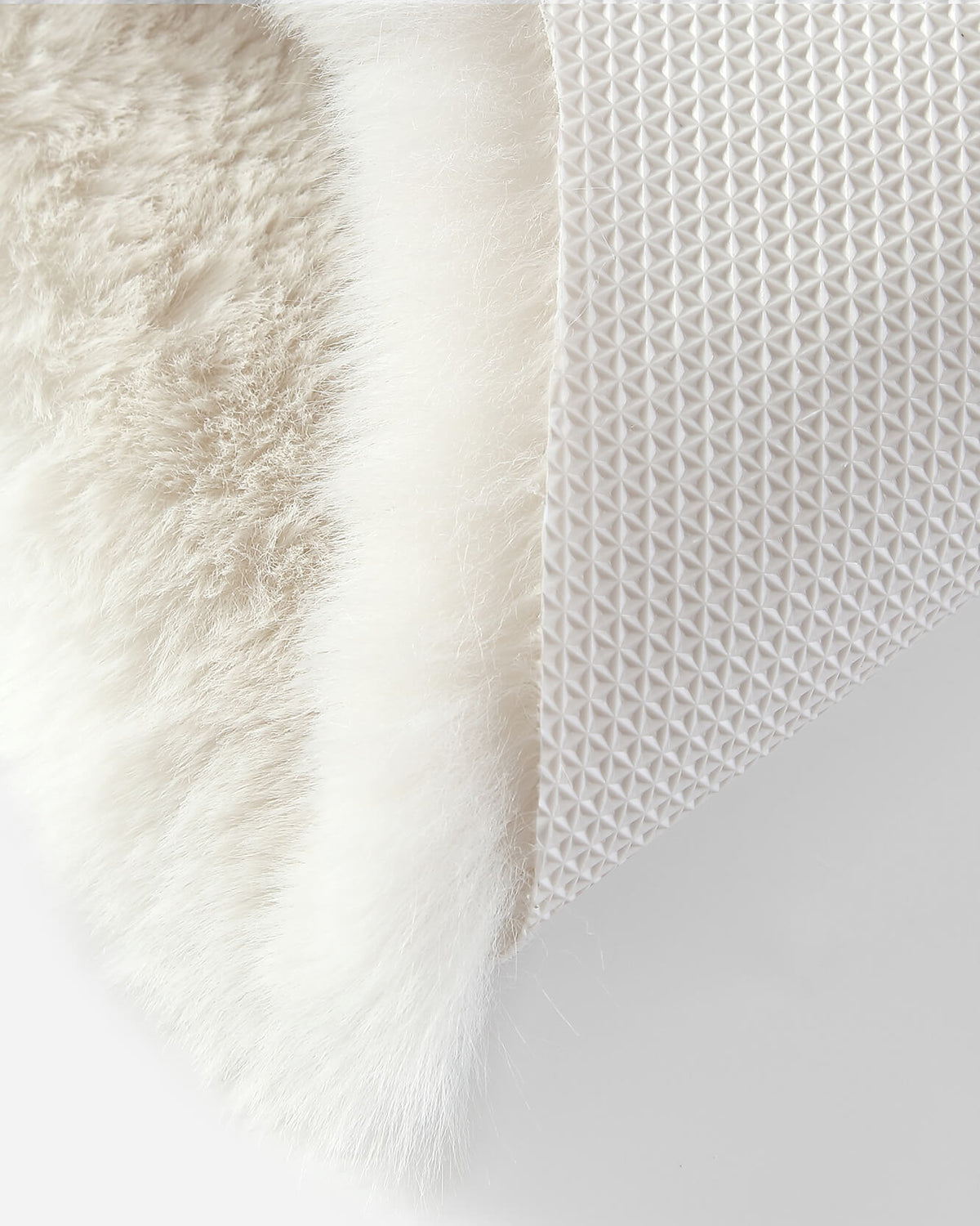 White faux fur rug edge with textured nonwoven backing