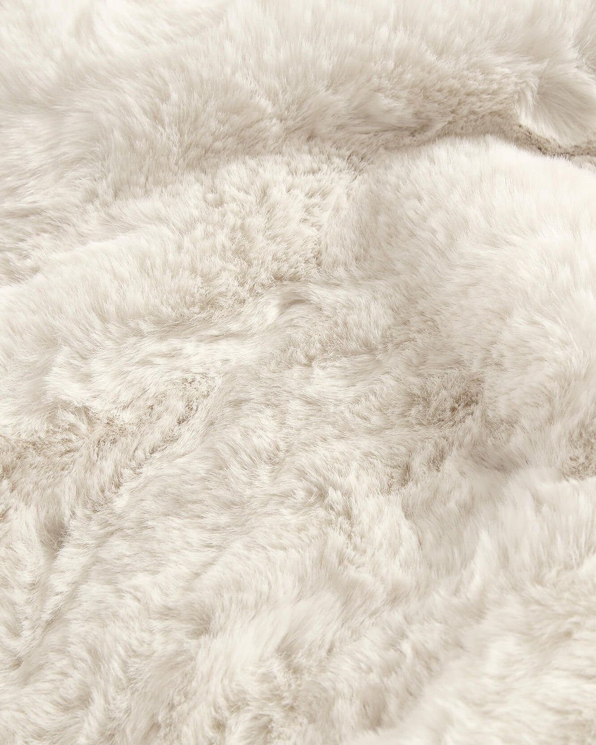 Close-up of white faux fur rug with plush shag pile