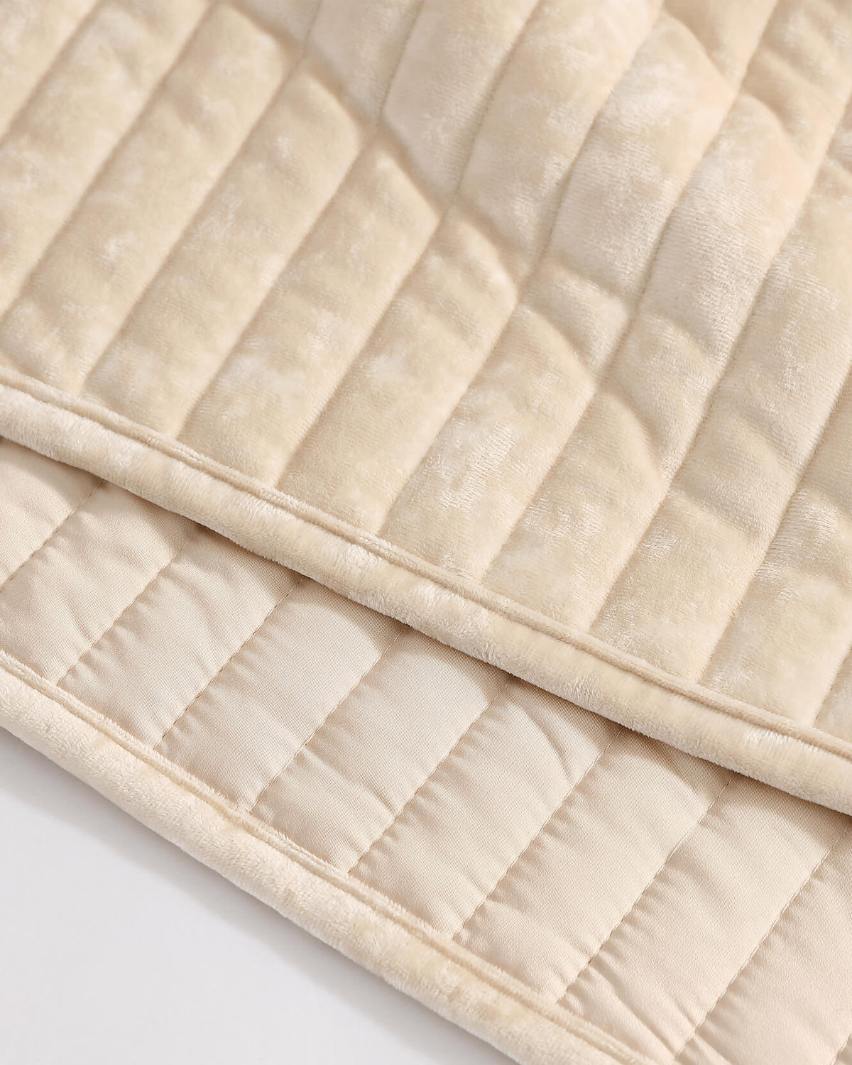 Cream velvet quilt close-up showing channel stripes and quilted layers.