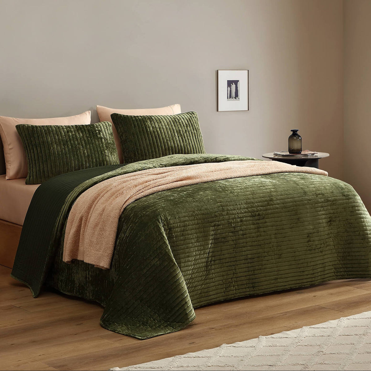 Olive green velvet quilt on a bed with vertical channel stitching texture.