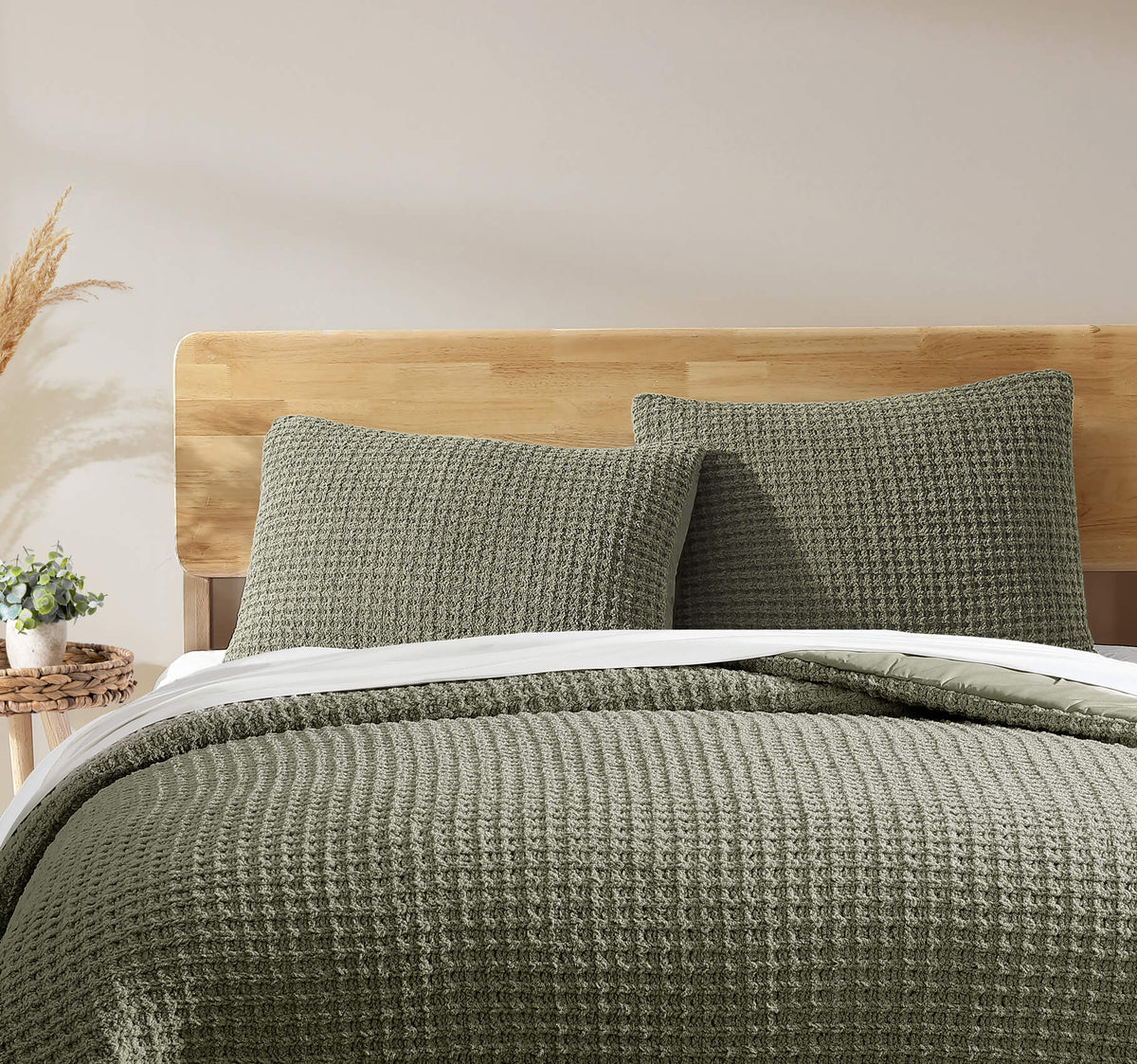 Olive green waffle comforter on bed with two matching textured square shams