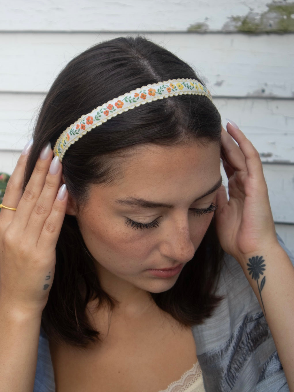 Skinny headband with multicolor floral trim, worn across dark hair