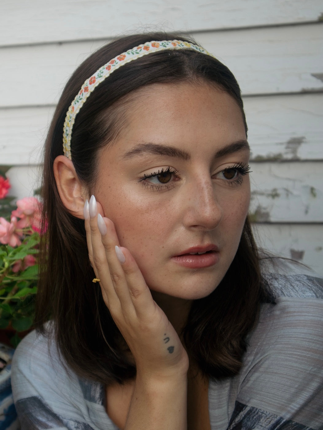 Multicolor floral skinny headband worn across dark hair, close-up view