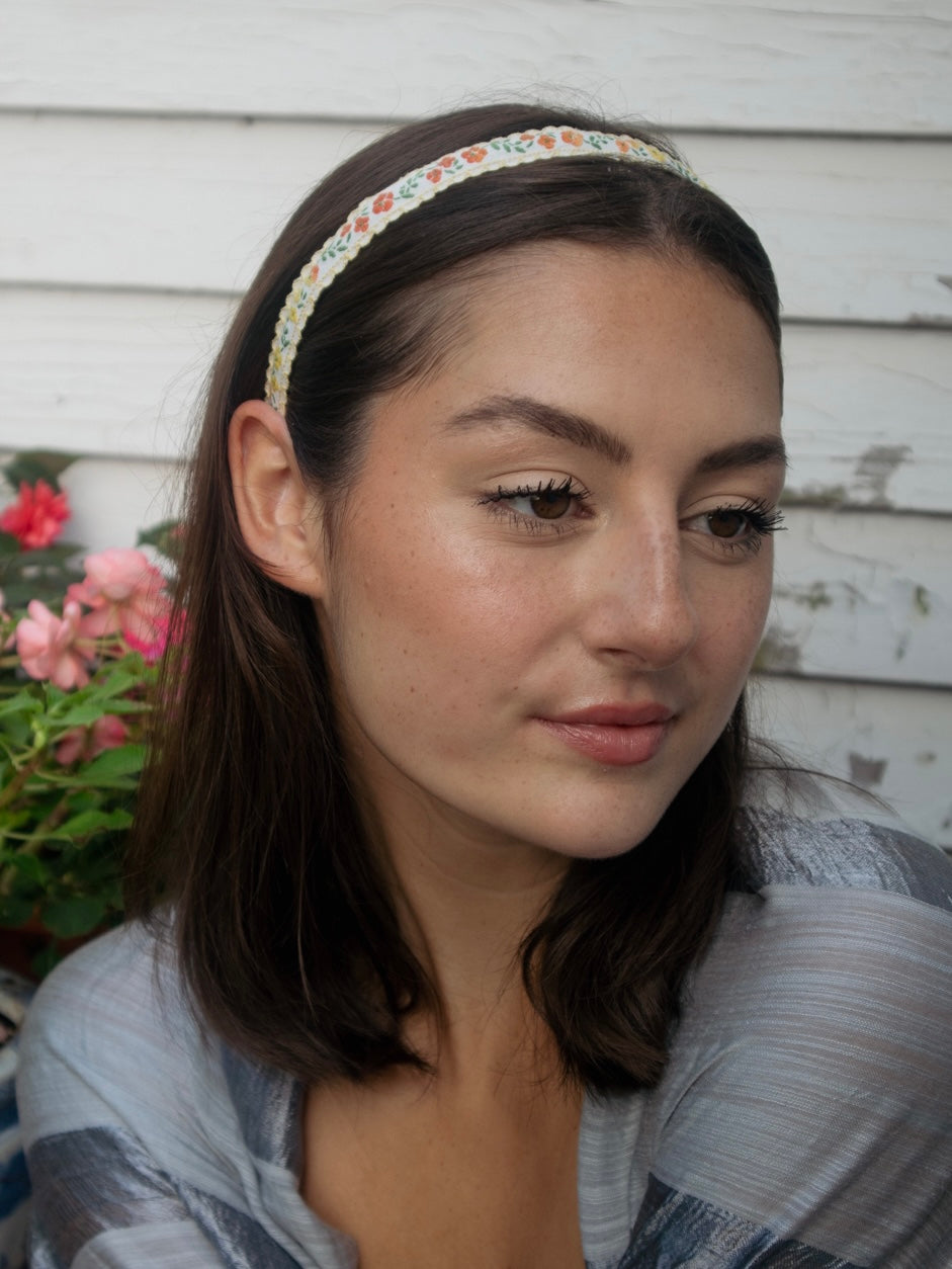 Floral skinny headband with multicolor trim, styled across dark hair