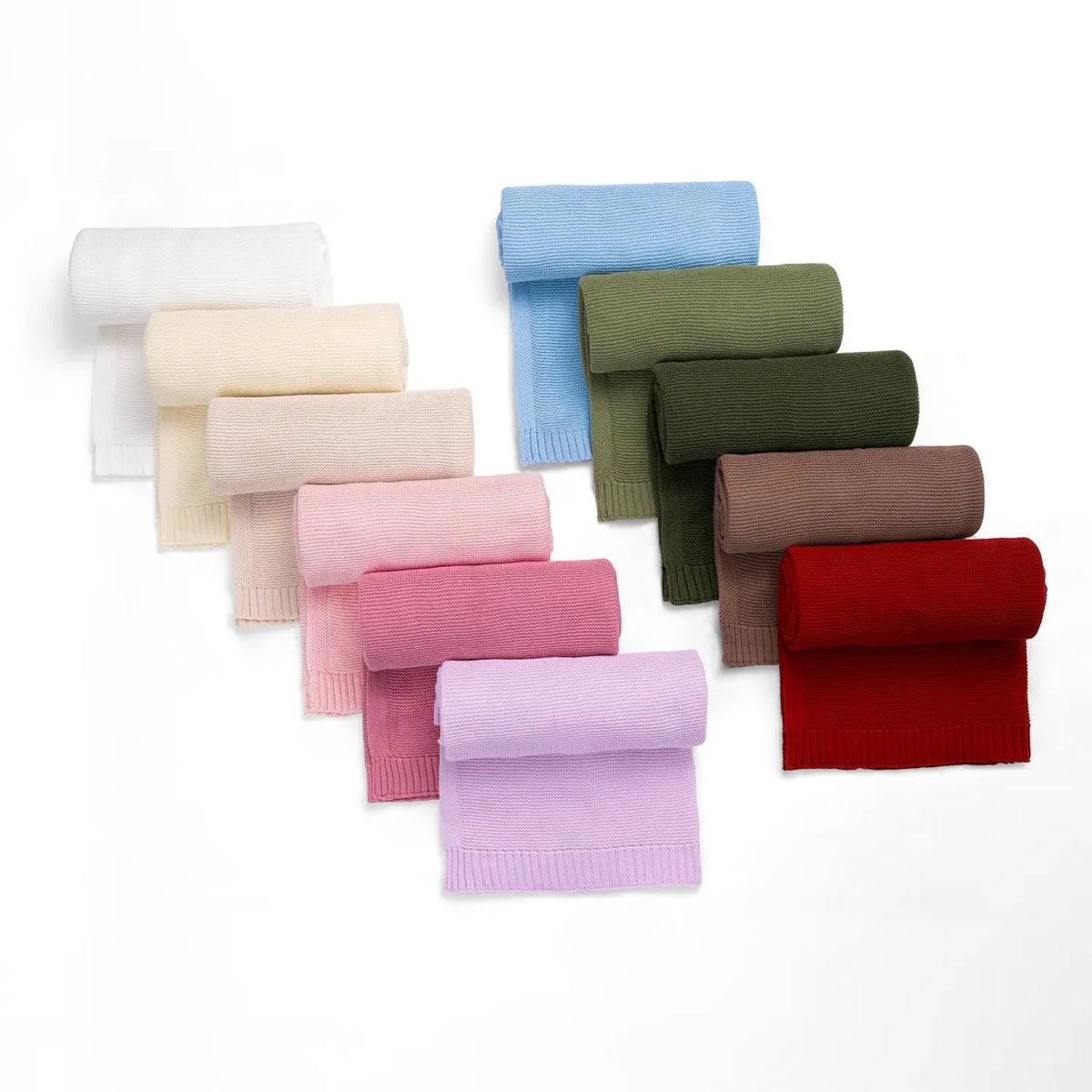 Assorted folded knit baby blankets on a white background, featuring the cream blanket.