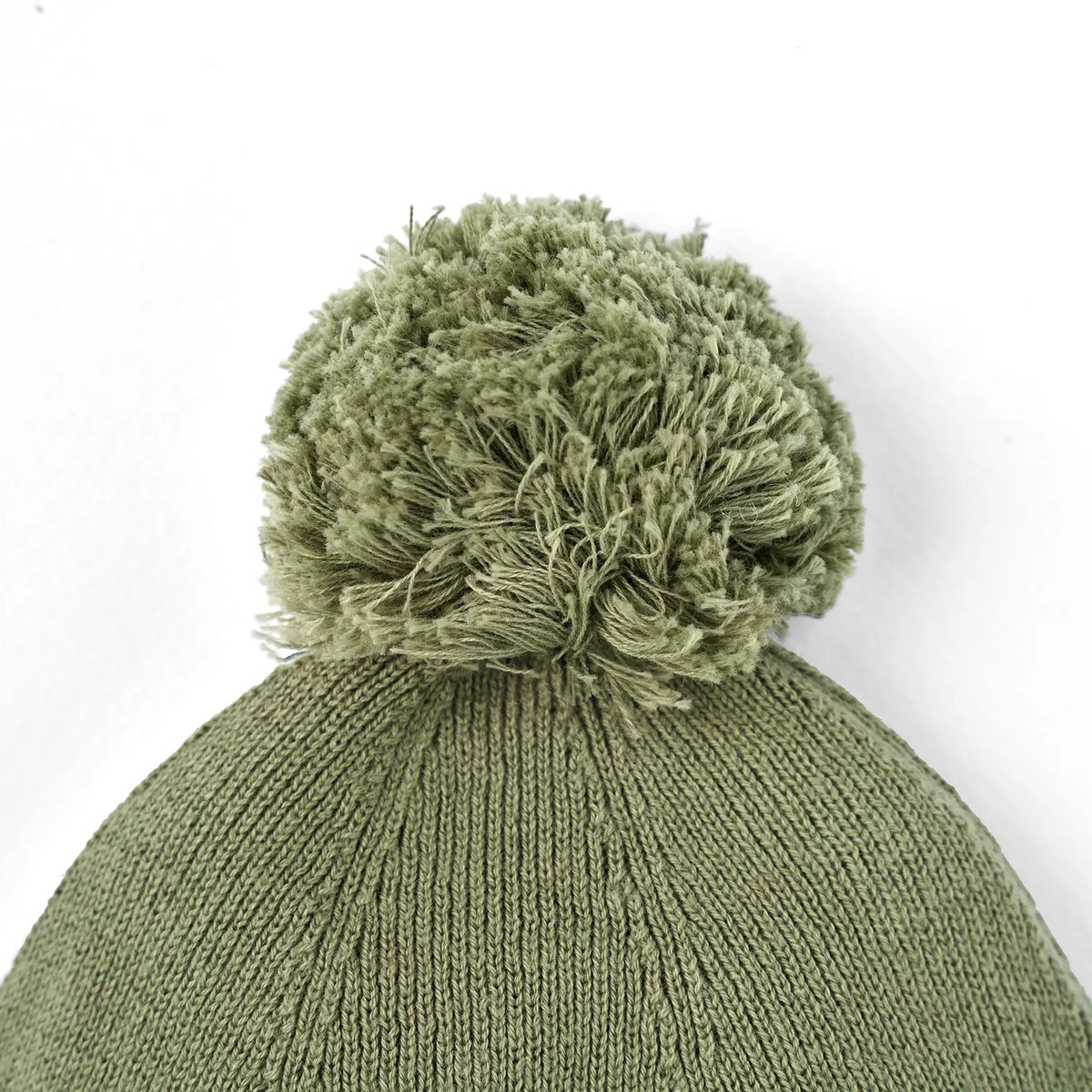 Sage green knit baby beanie with textured knit and pom-pom on top.