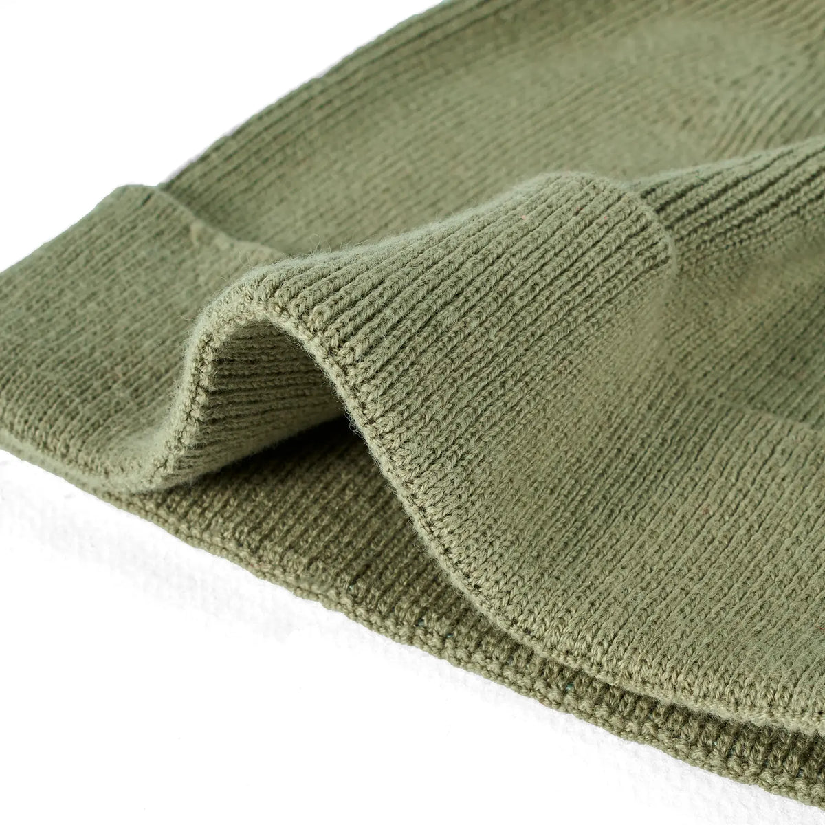 Sage green knit baby beanie with folded brim and fine ribbed texture.
