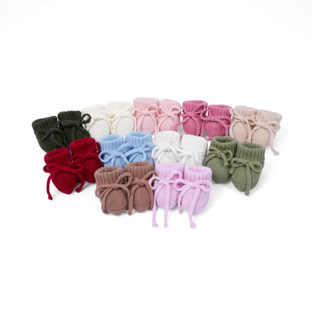 Assorted knitted baby booties in many colors, including rose pink pairs