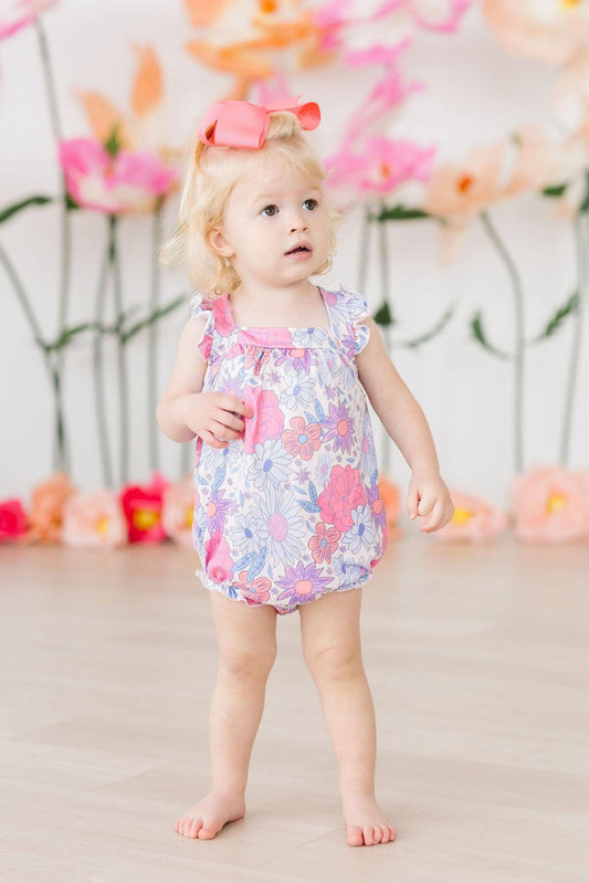 Pastel floral ruffle romper with cross-back straps and short bubble legs