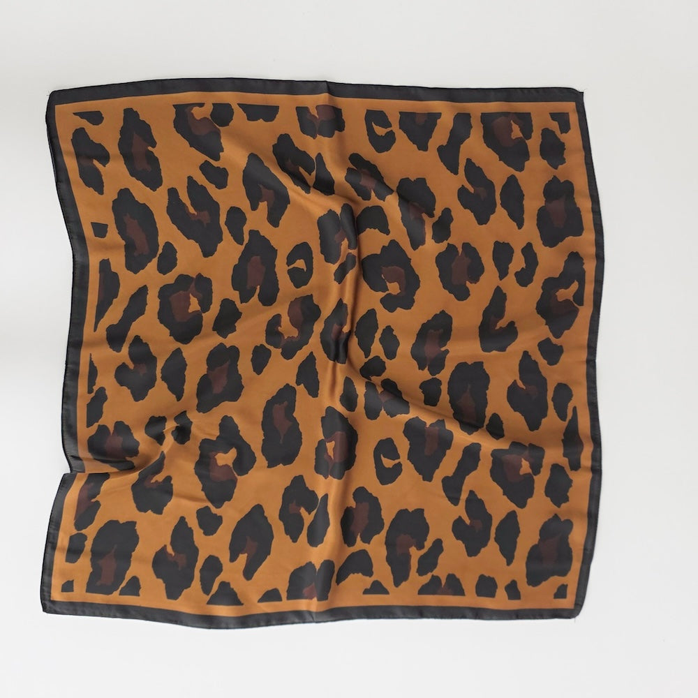 Brown leopard square scarf with black spots and dark border, folded flat