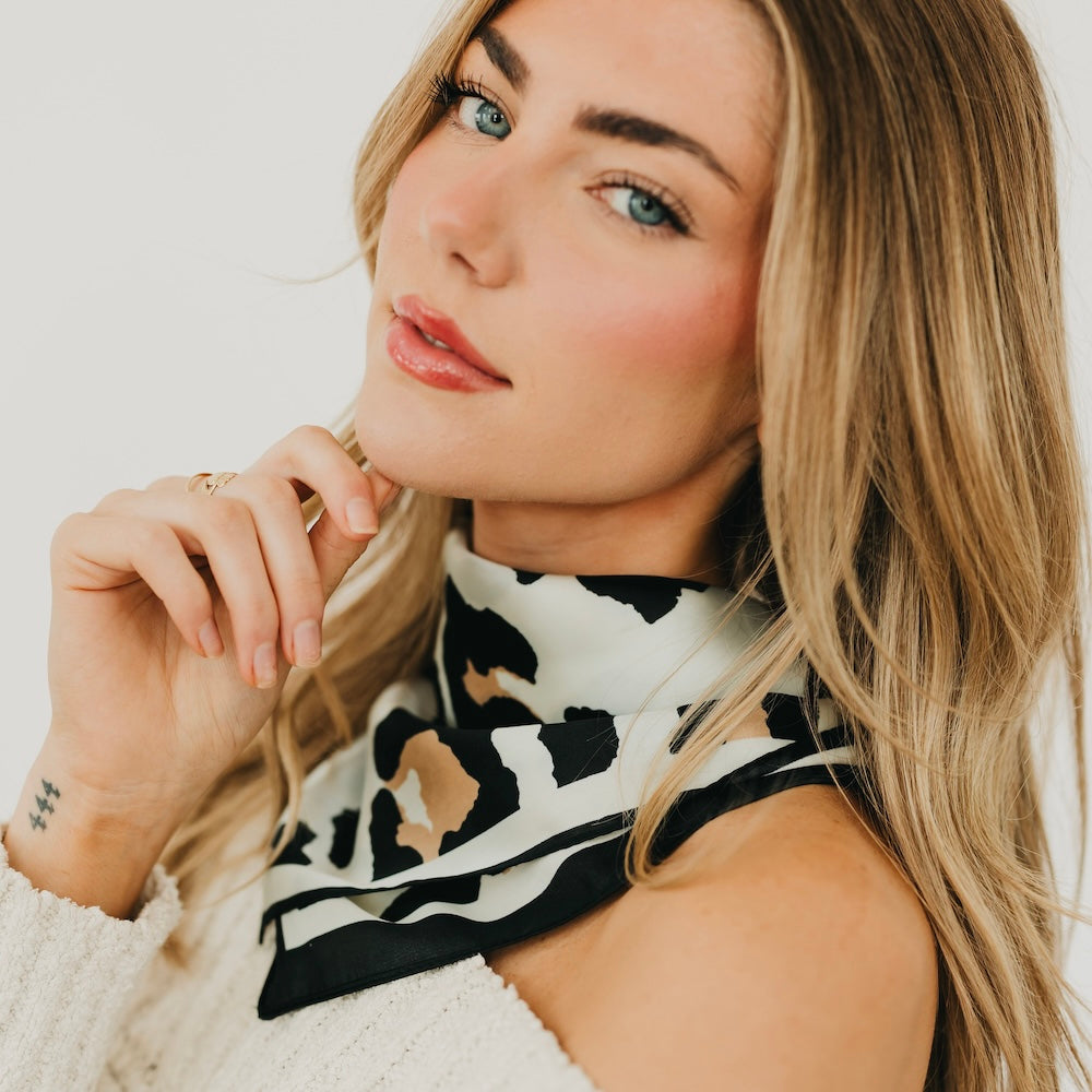 Black and cream leopard square scarf with bold pattern, styled around the neck