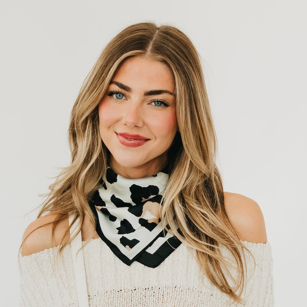 Leopard square scarf in black and cream with border print, worn on the shoulders