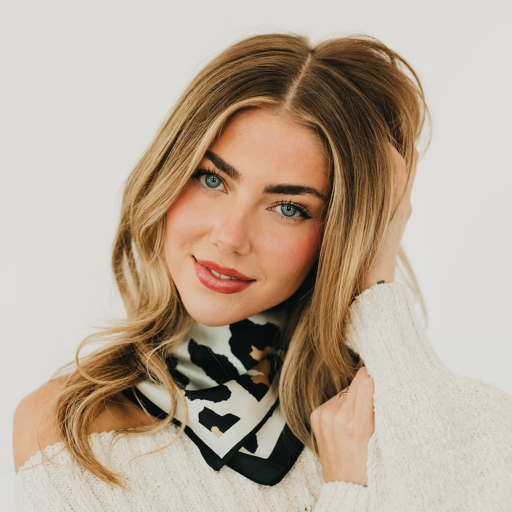 Leopard print square scarf in black and cream, worn as a neck tie