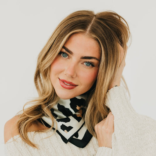 Leopard print square scarf in black and cream, worn as a neck tie