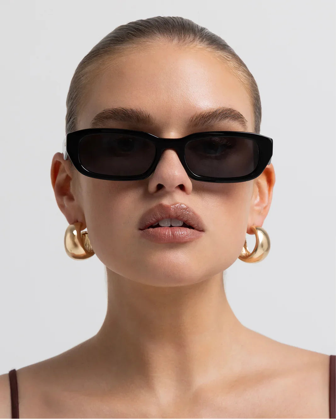 Polarized sunglasses with dark frame and brown lenses, front view close-up