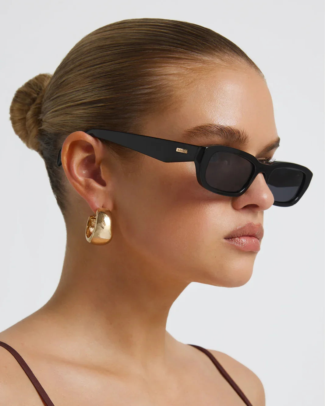 Polarized sunglasses with dark frame, brown lenses, side profile view