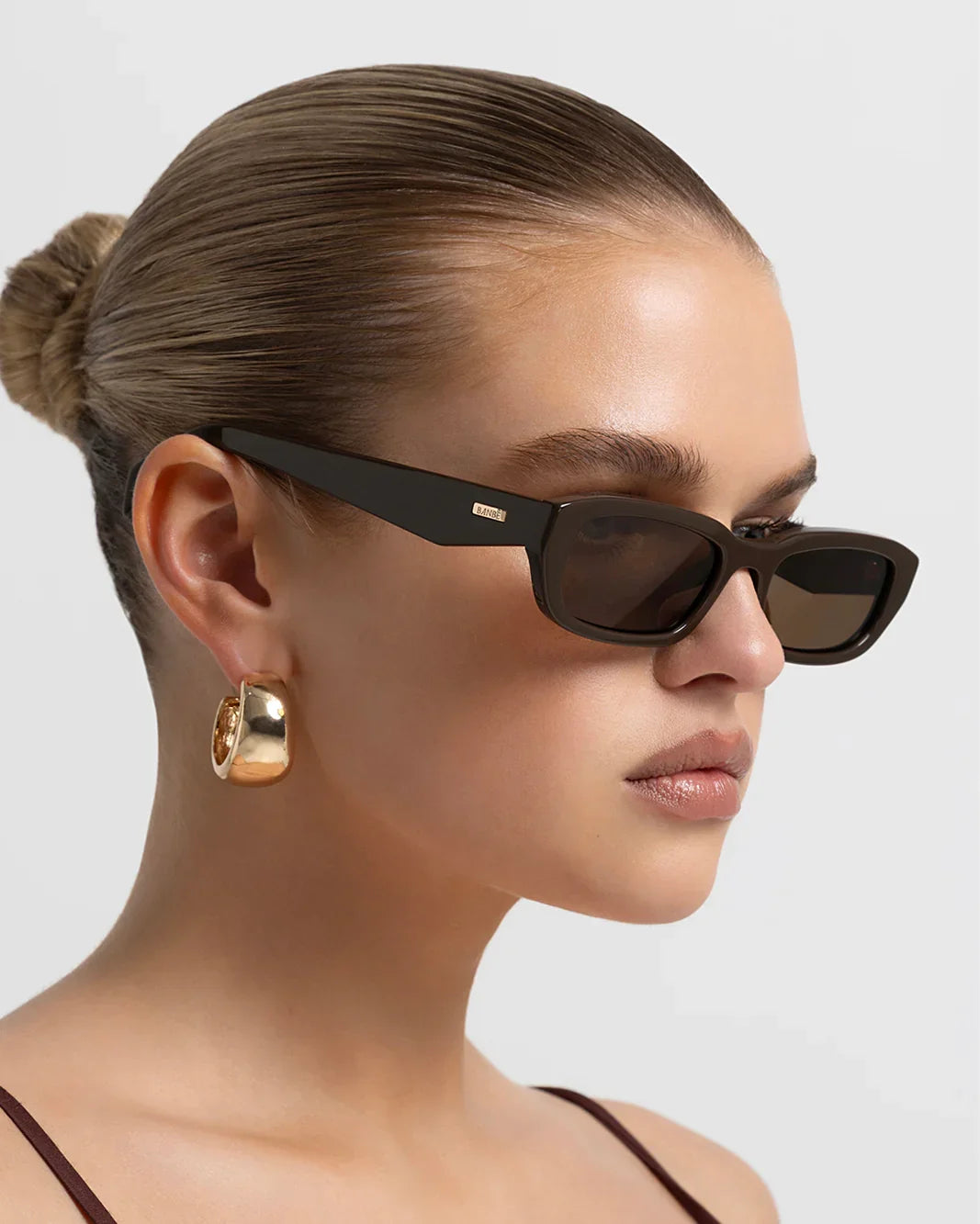 Polarized sunglasses with dark frame and brown lenses, side profile view