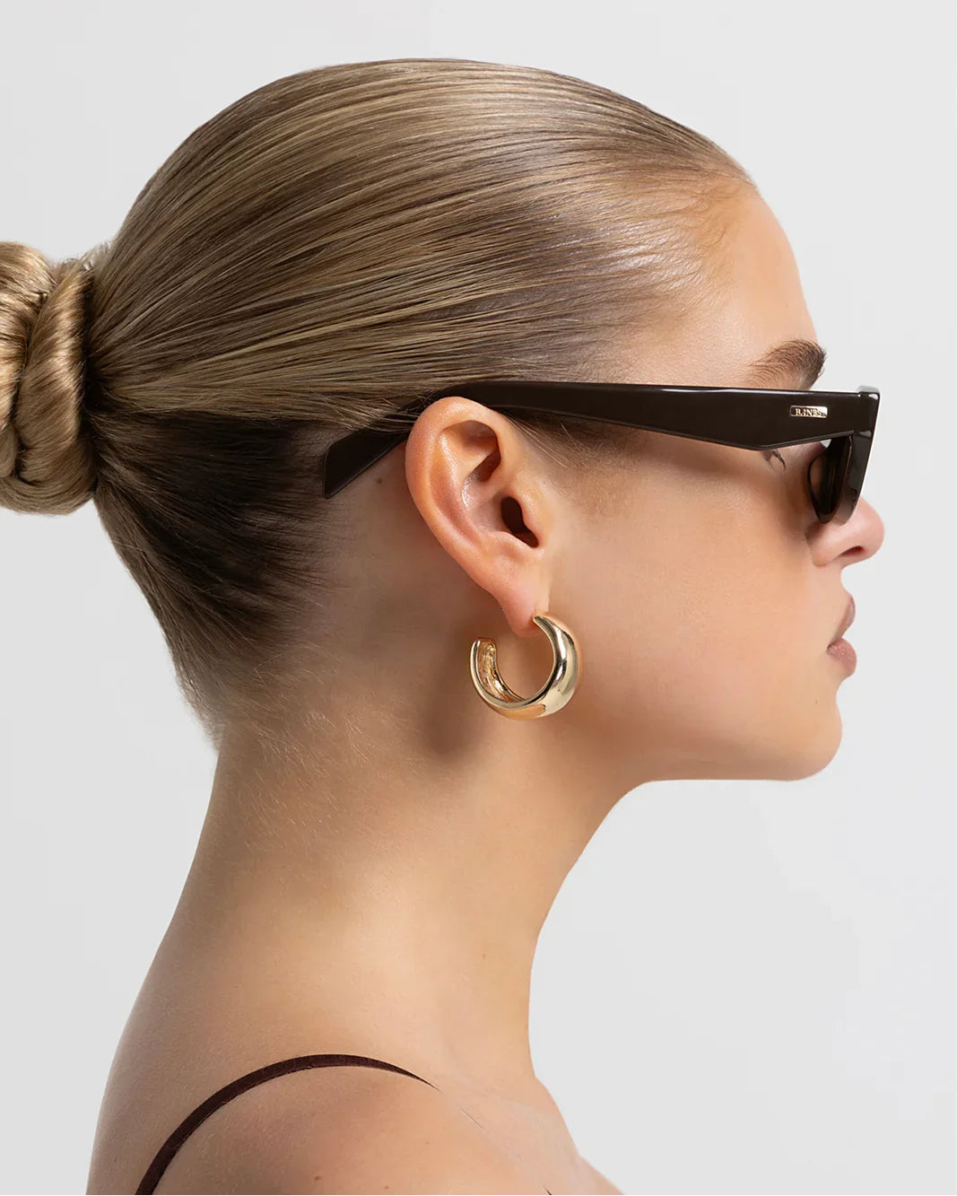 Polarized sunglasses with dark frame and brown lenses, side profile view