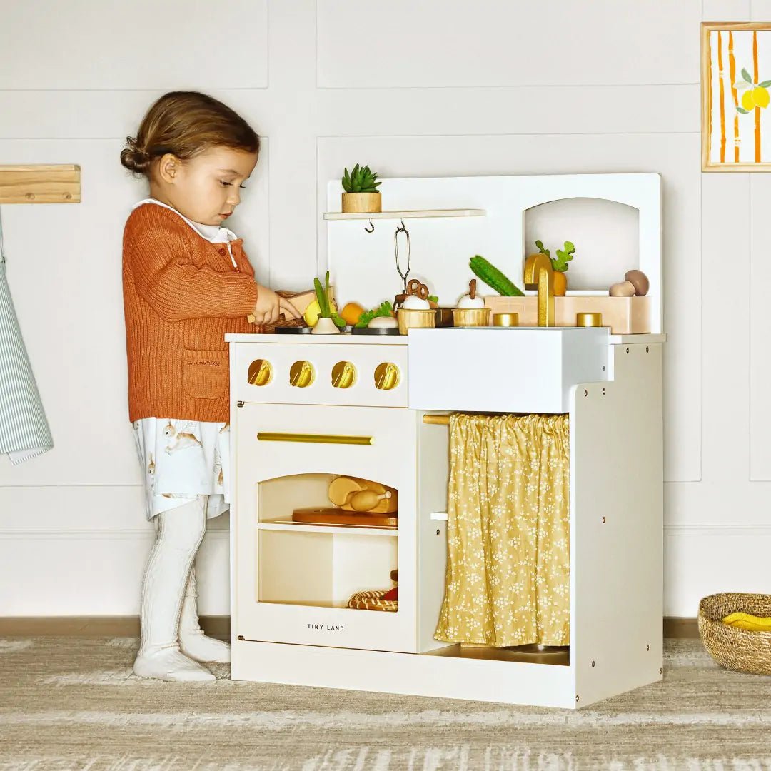 Wooden play kitchen with oven, sink, toy food and gold curtain