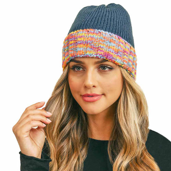 Dark teal knit fleece beanie with colorful striped band and folded cuff