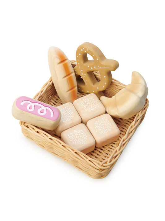 Woven basket with wooden toy bread pieces, bun, and sliced loaves in beige and purple
