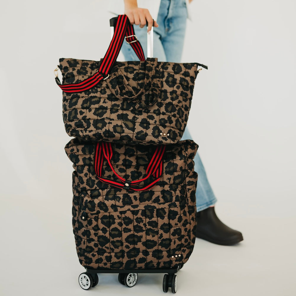 Quilted roller tote bag with leopard print and red-striped handles, rolling wheels