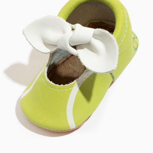 Lime green baby shoe with white knotted bow, open toe view