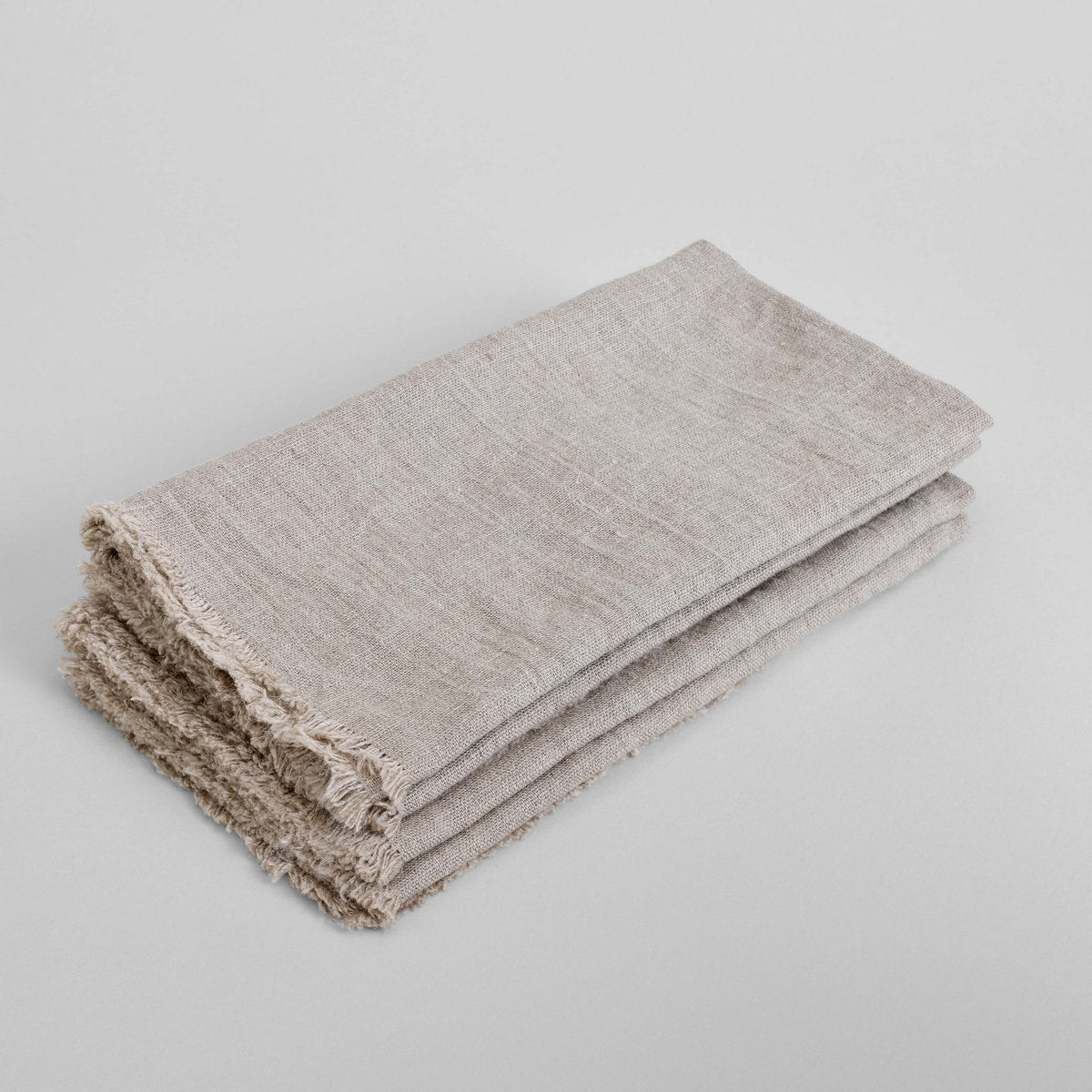 Natural flax linen napkin, folded with textured weave and fringed edges