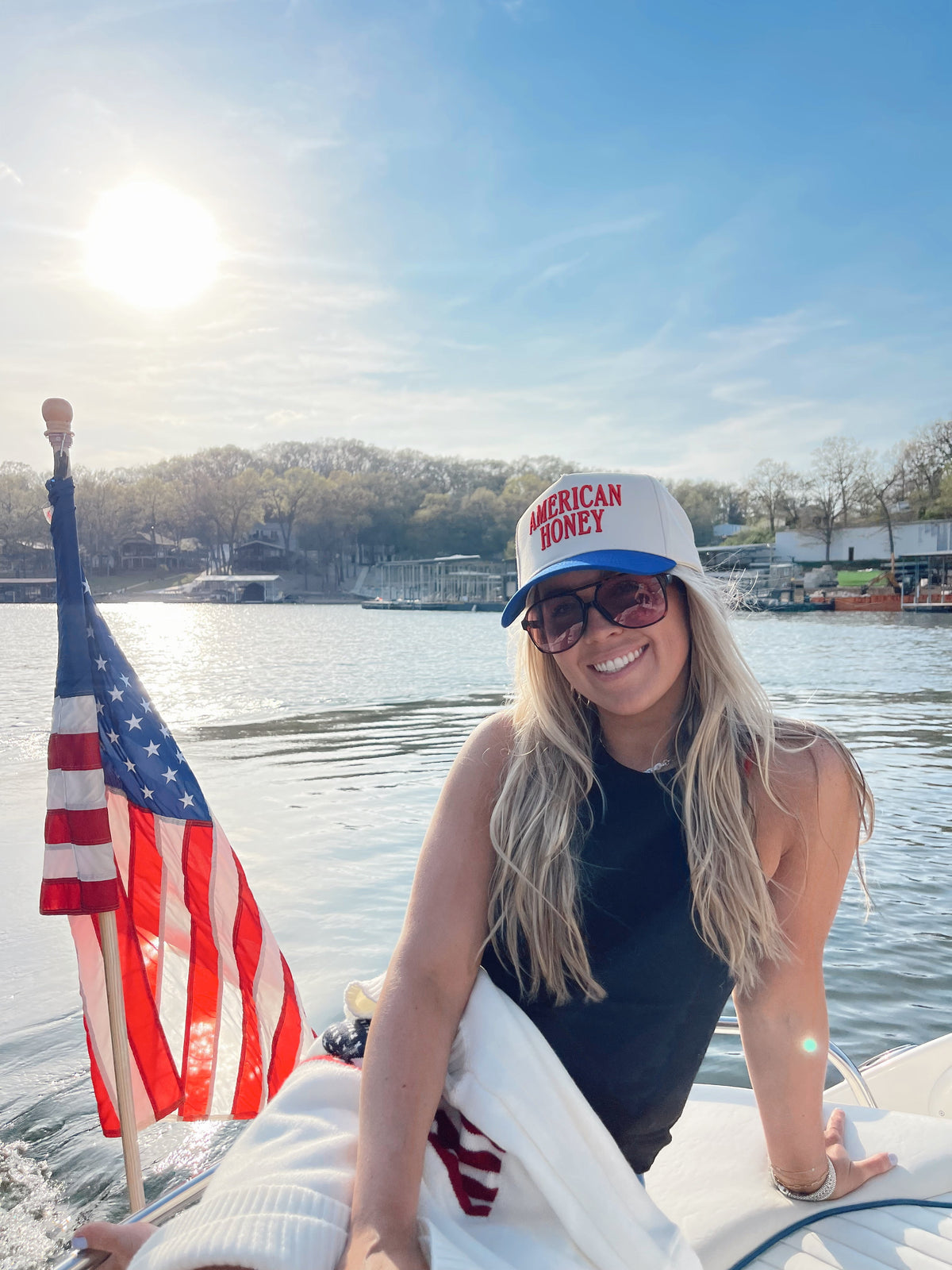 Vintage trucker cap, white crown and blue brim, red “AMERICAN HONEY” logo worn on head.