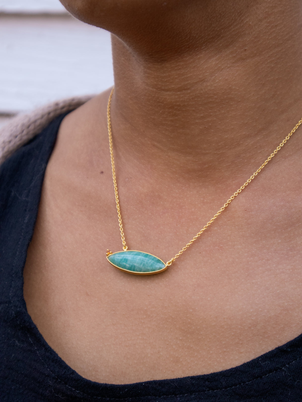 Gold chain necklace with oval blue-teal stone pendant