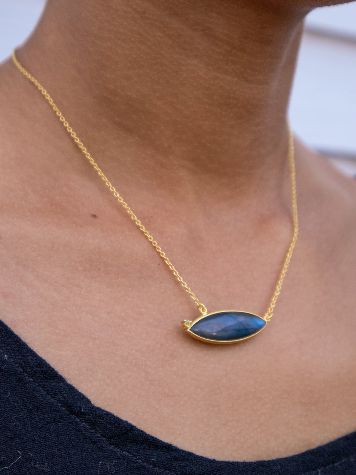 Gold chain necklace with small oval blue gemstone pendant