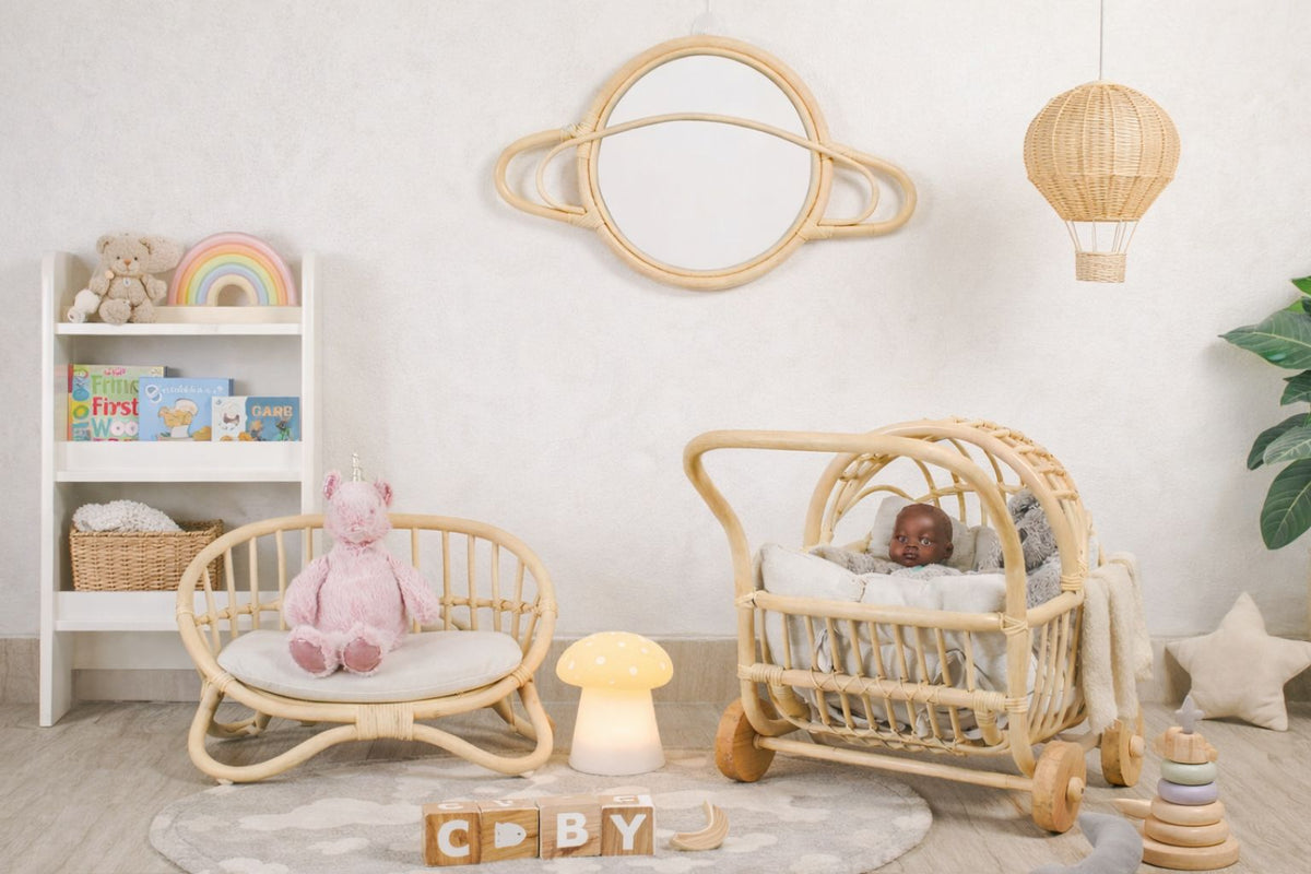 Natural rattan miniature doll couch with curved frame and woven seat, shown in a nursery scene