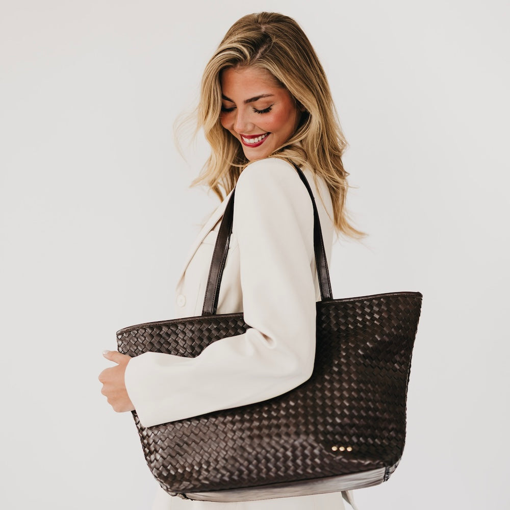 Woven dark brown tote bag with short handles and small gold snap detail