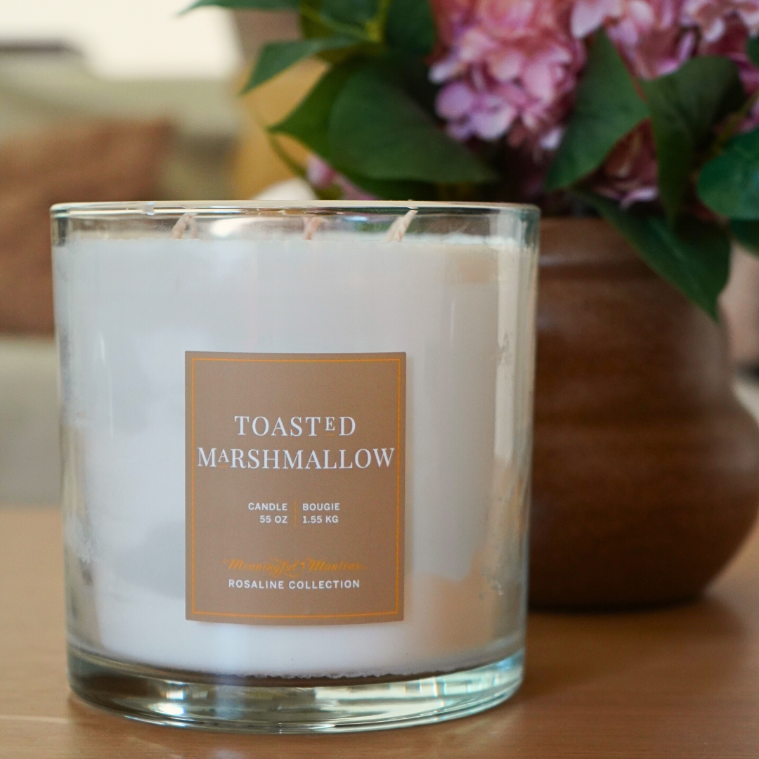 Toasted Marshmallow candle in a clear glass jar with three wicks and a tan label