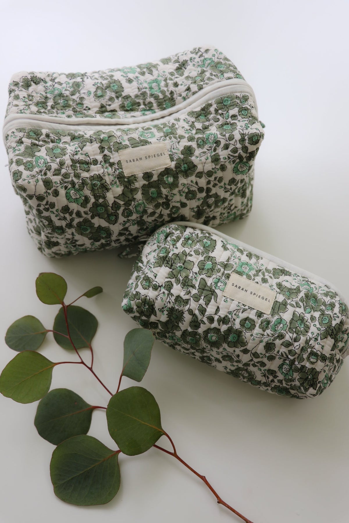 Olive floral toiletry bag set with two quilted zip pouches in different sizes.