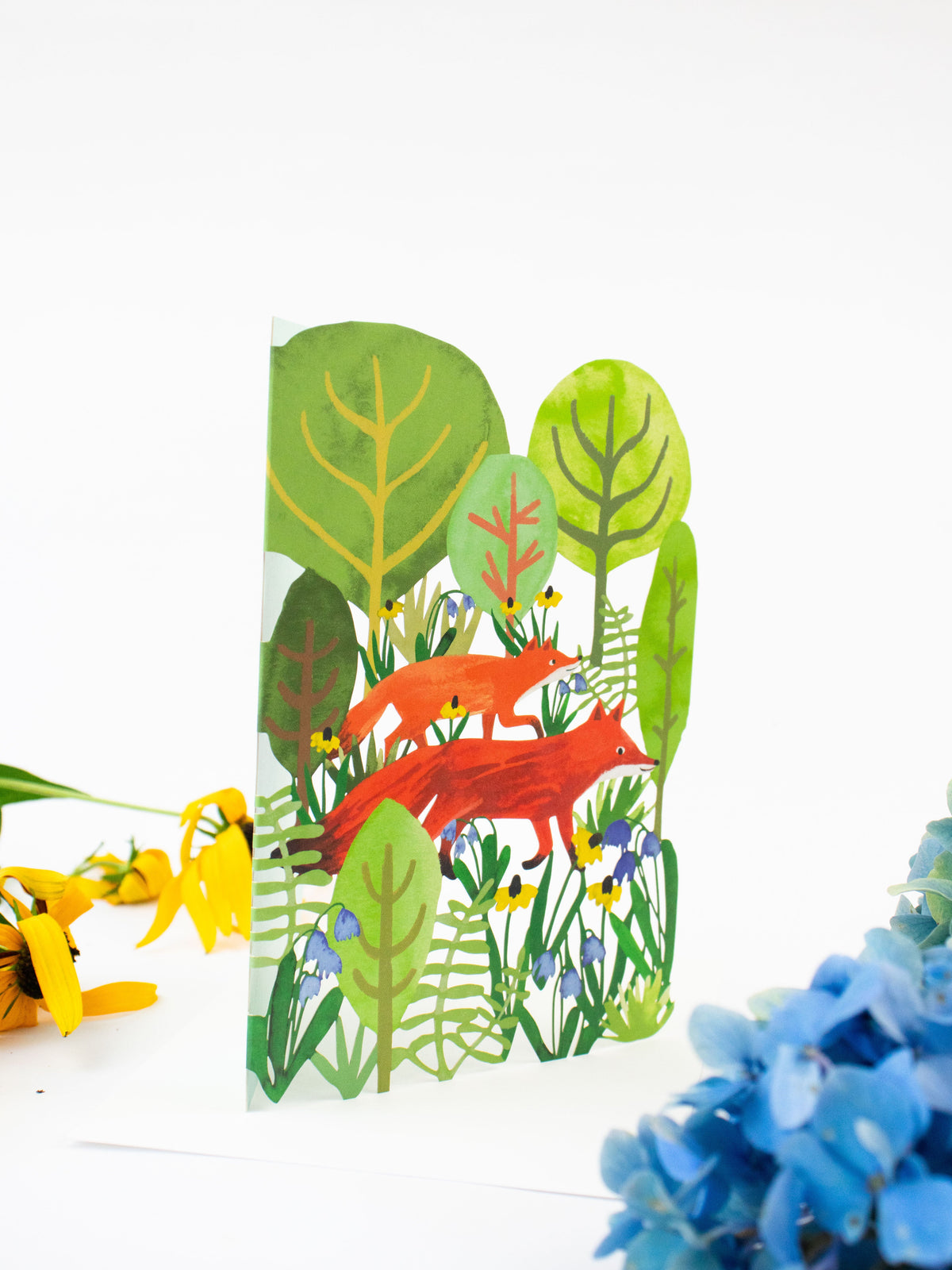 Lasercut blank greeting card with forest cutout trees and red fox design