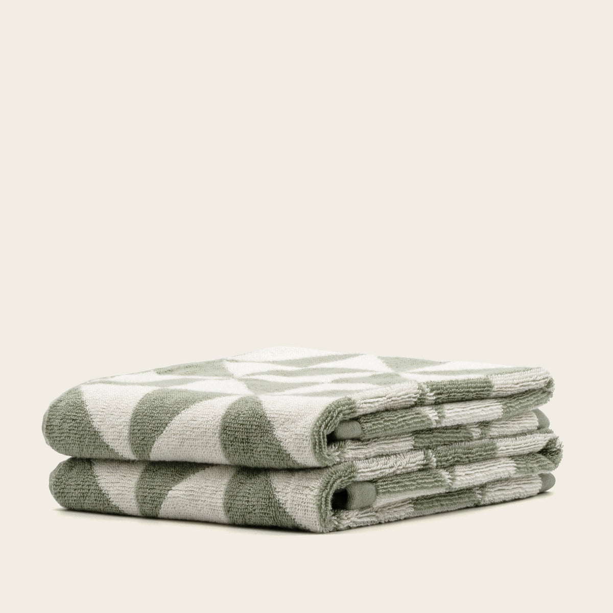 Sage green and ecru striped cotton towels, neatly folded stack