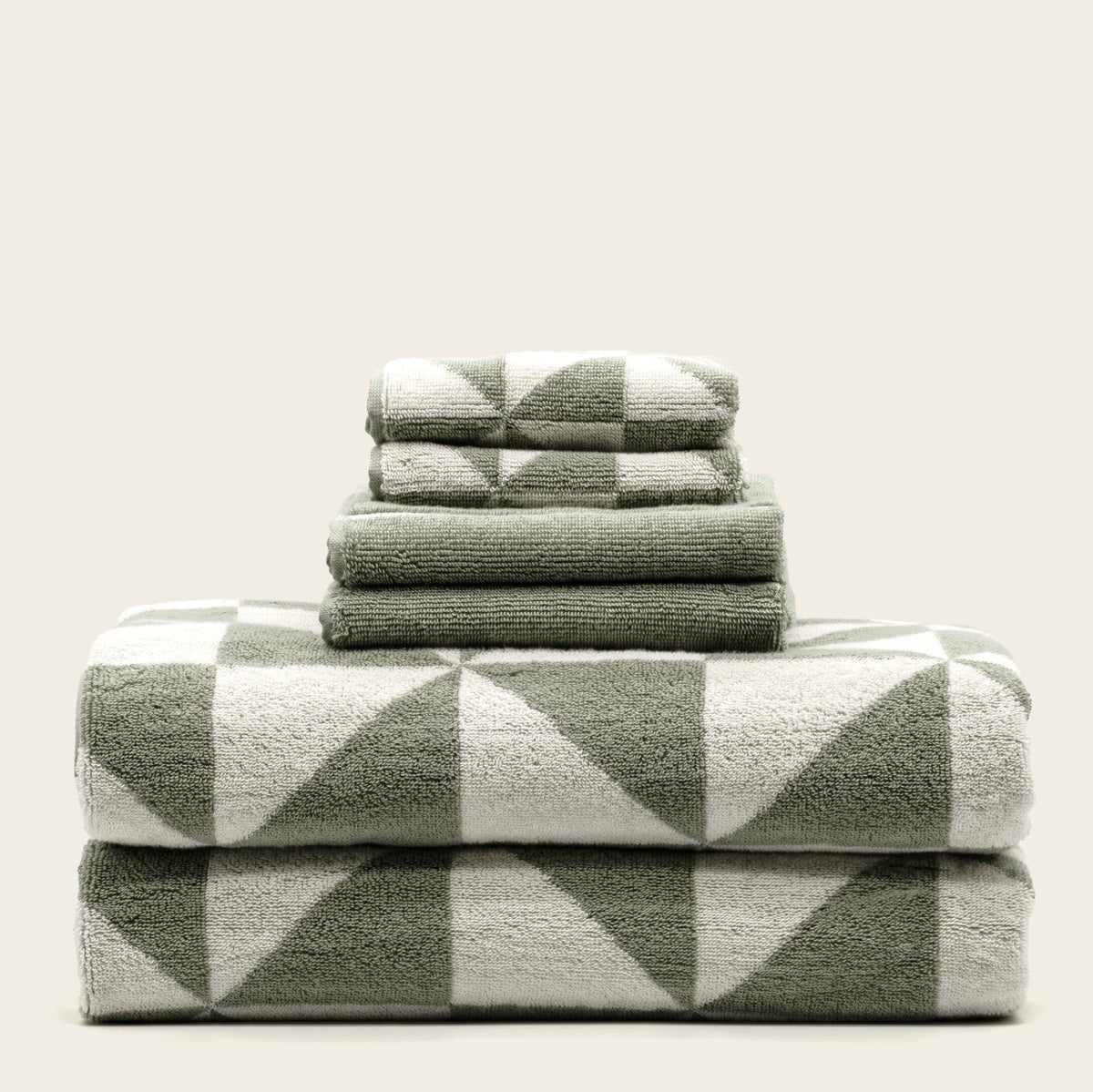 Sage green and ecru cotton towels with bold geometric check pattern, folded stack