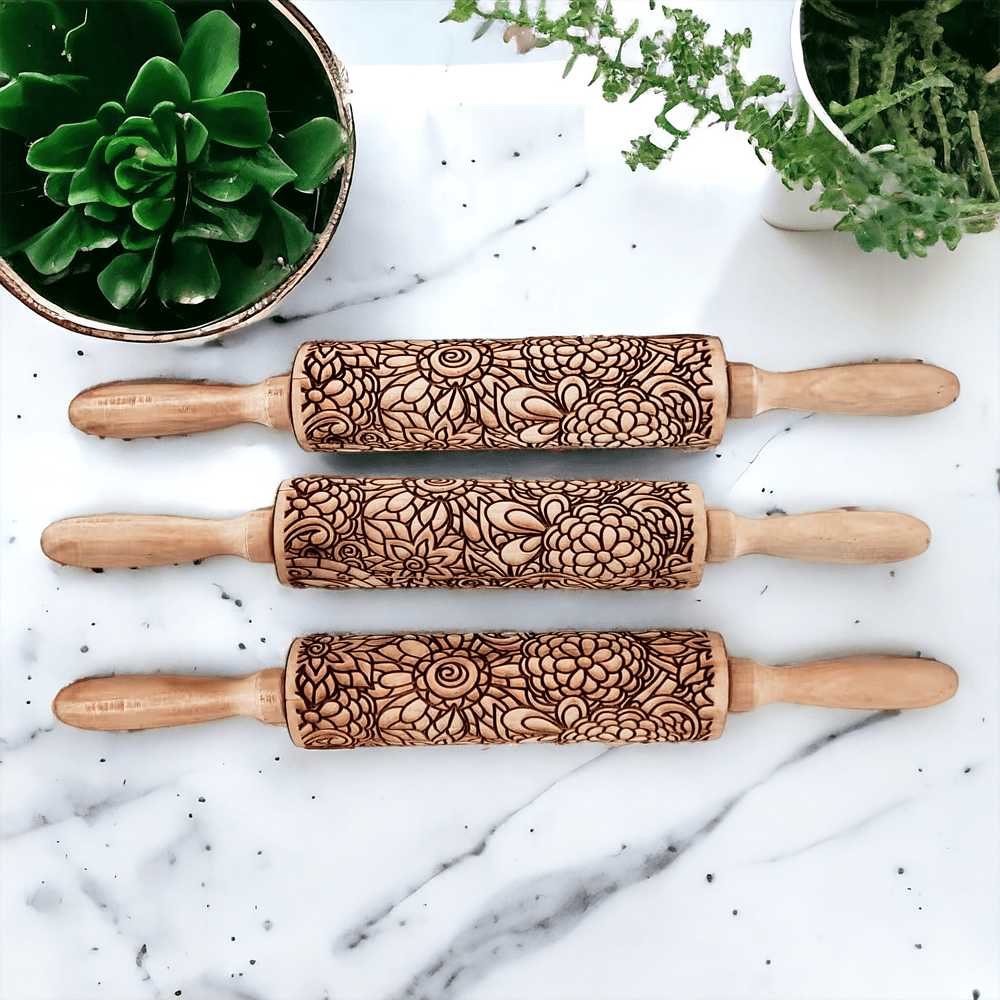 Set of three wooden rolling pins with brown floral/leaf carved designs