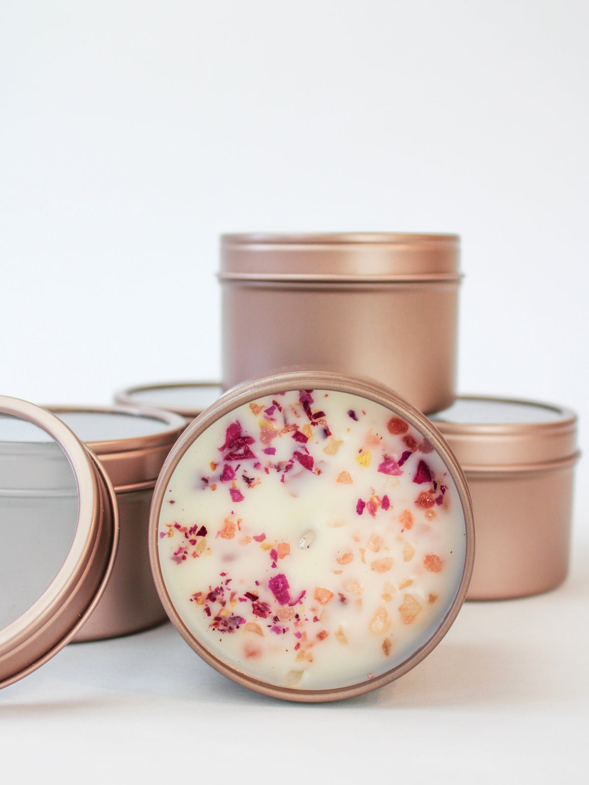 Botanical soy wax candle set in rose-gold tins with dried flower petals on wax tops
