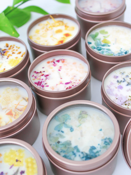 Set of botanical soy wax candles in rose-gold tins with mixed-color dried flower wax