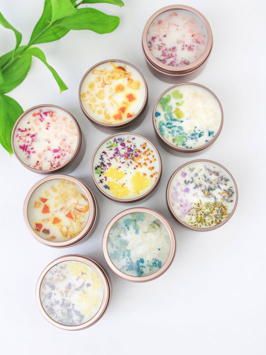 Botanical soy wax candles in rose-gold tins with colorful dried flower wax tops